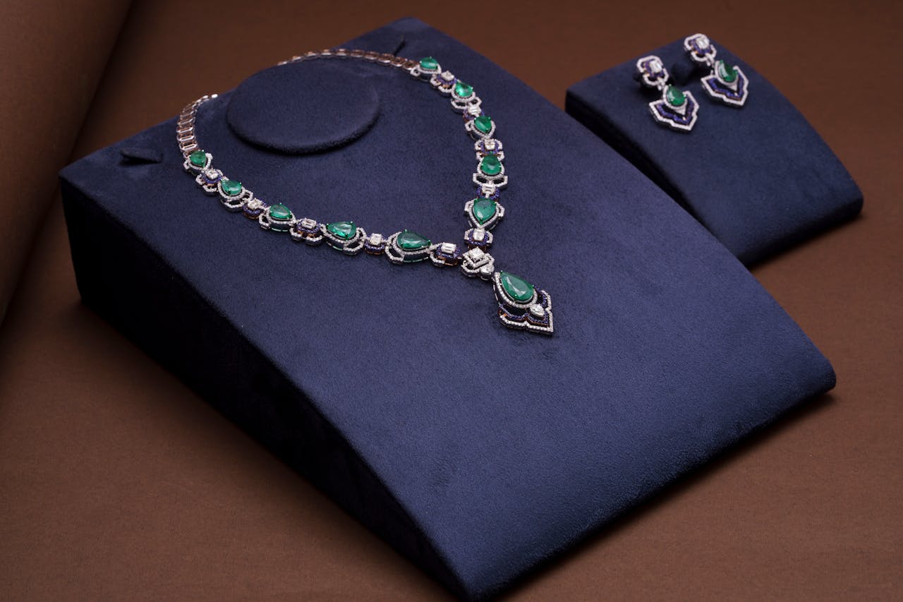 Elegant emerald necklace and earrings set on velvet background, perfect for showcasing luxury and style.