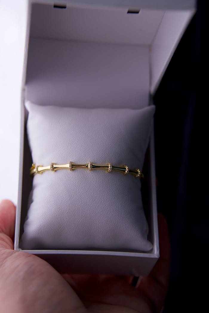 A refined gold bracelet displayed in an open white box, perfect for gifting.