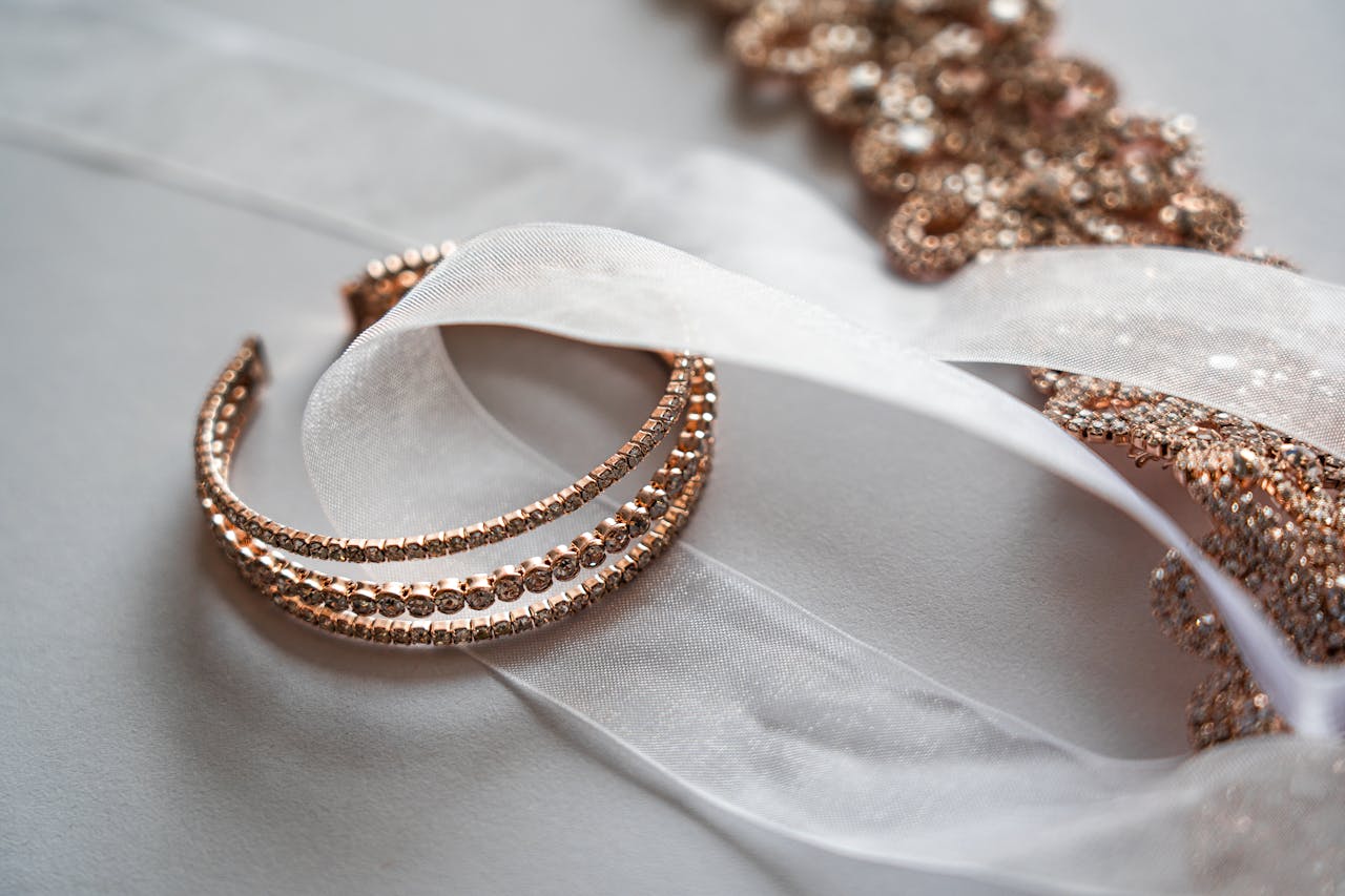 services-03 Close-up of luxurious rose gold jewelry on a sheer satin fabric, perfect for bridal occasions.