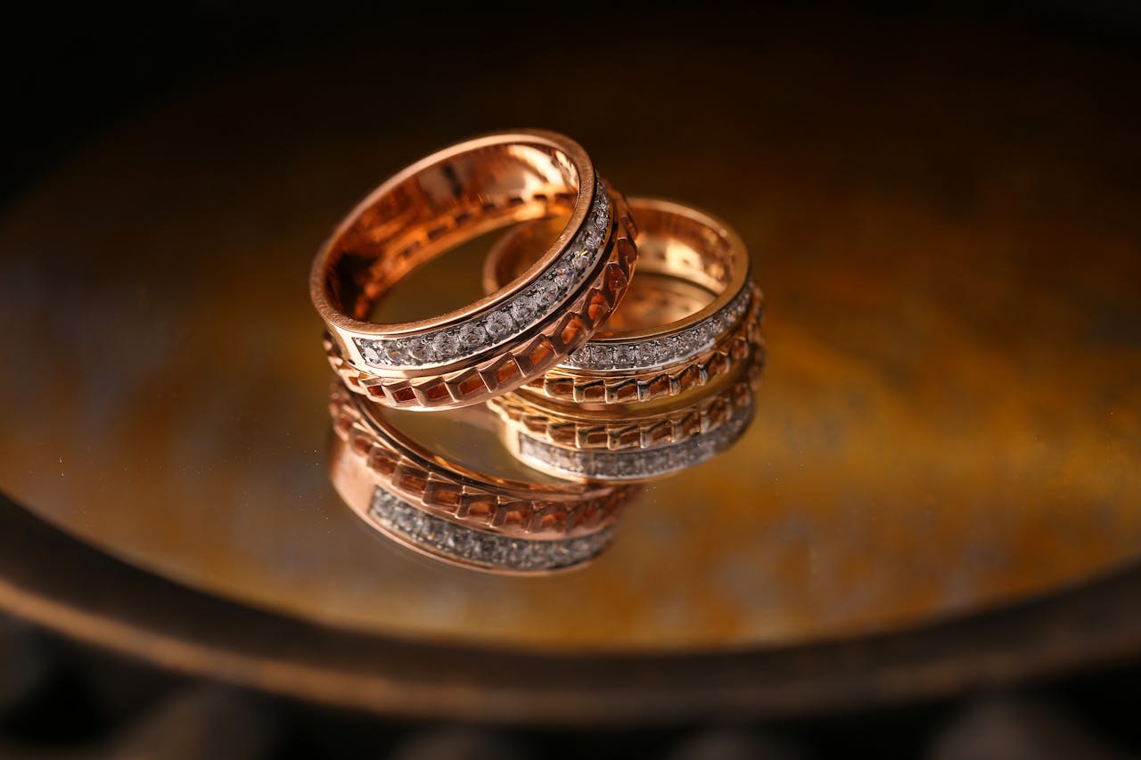 gallery-6 Close-up of luxury gold and diamond wedding rings reflecting light beautifully.